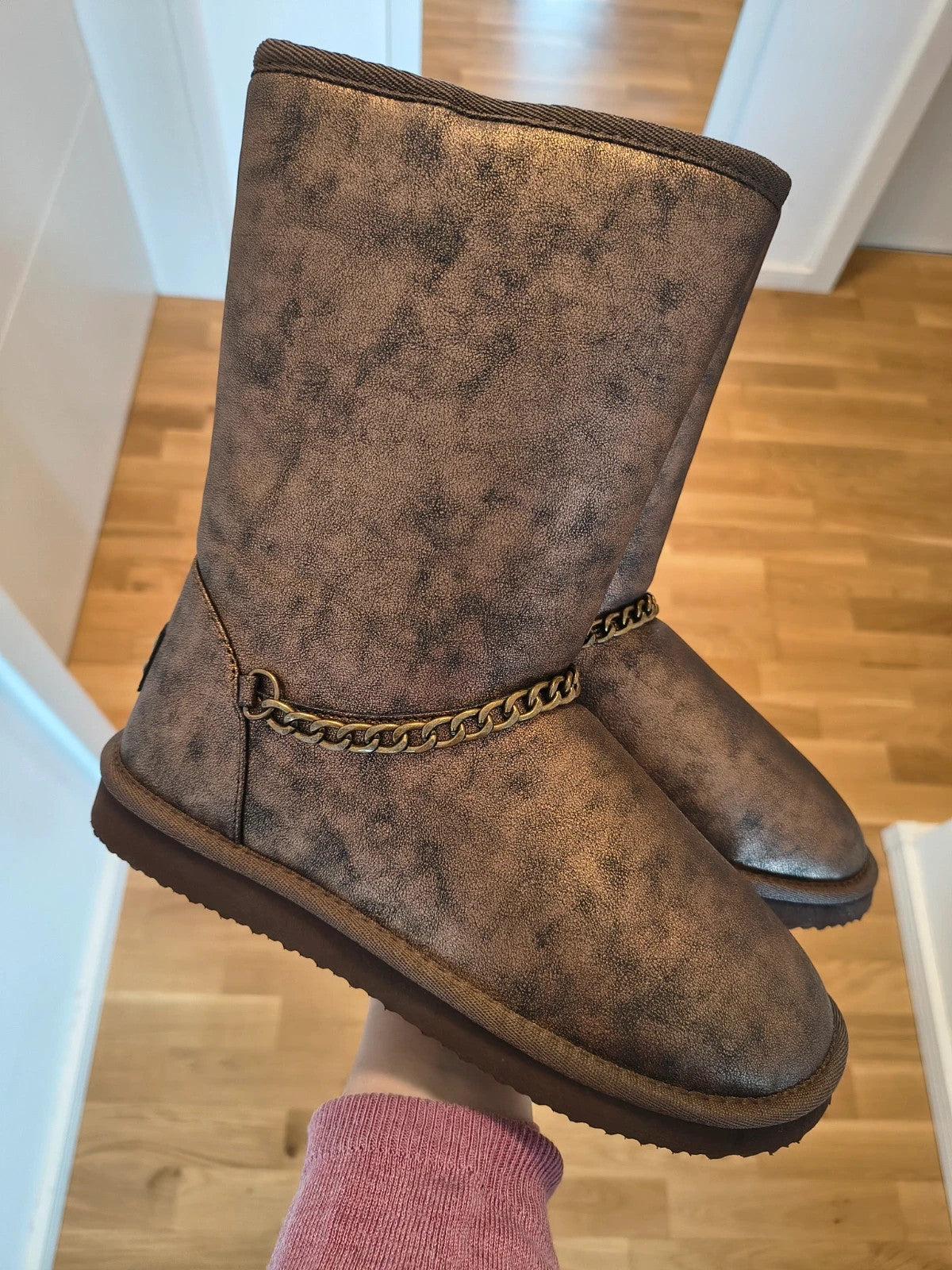 Lynfield brown slip-on boots with vintage look and decorative gold chain detail.