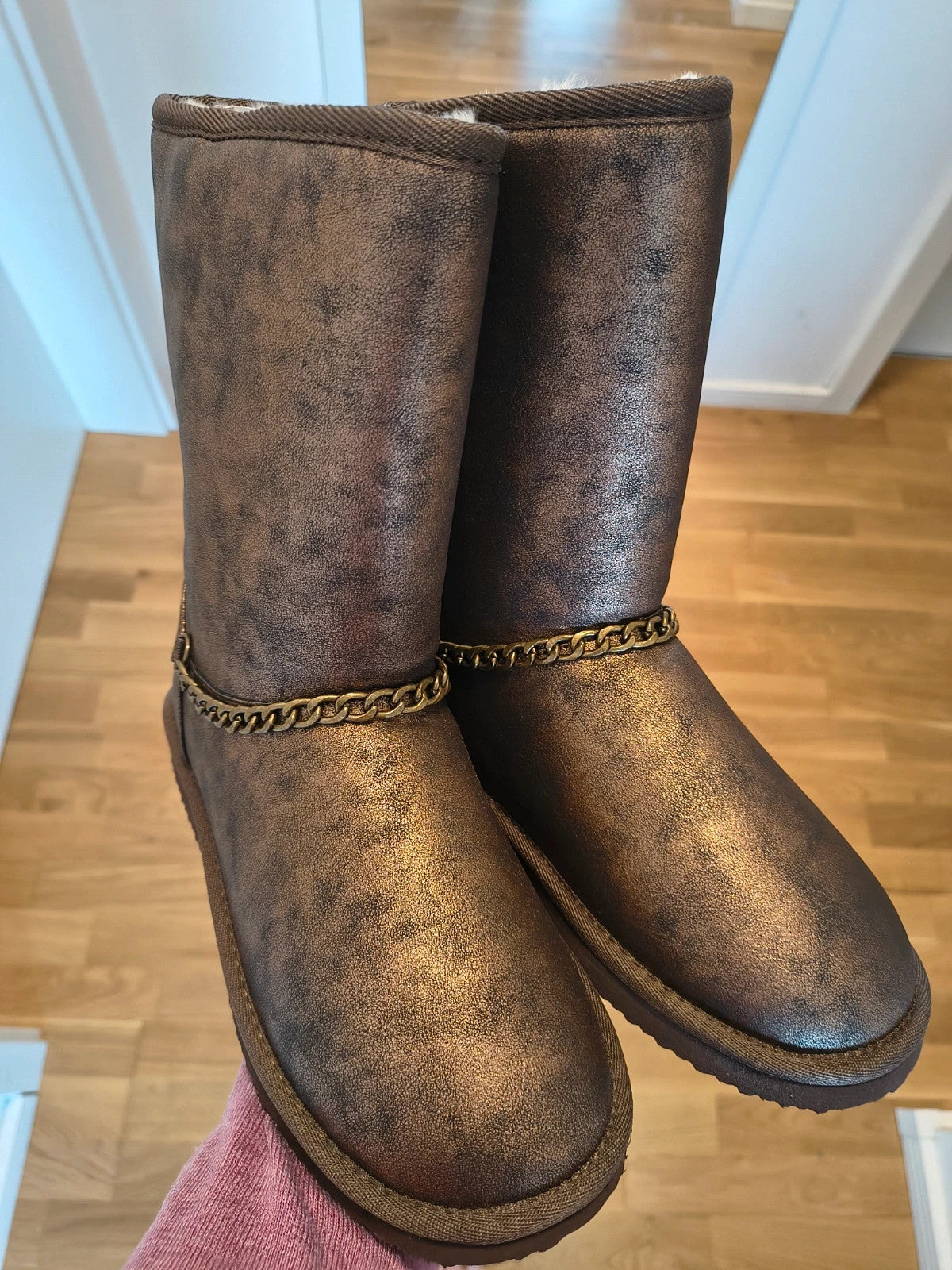 Lynfield brown slip-on boots with vintage look and decorative gold chain detail.