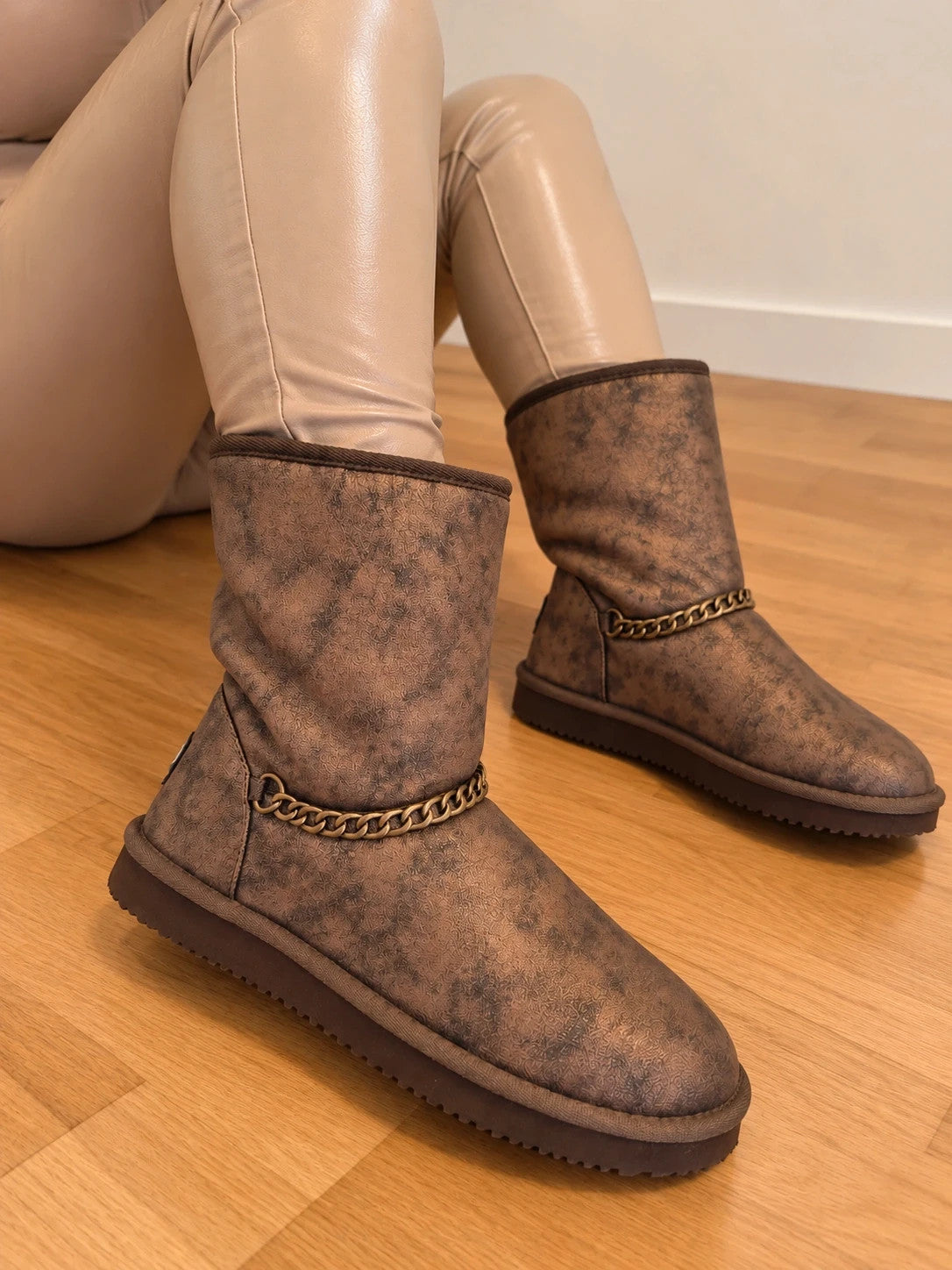 Lynfield brown slip-on boots with vintage look and decorative gold chain detail.
