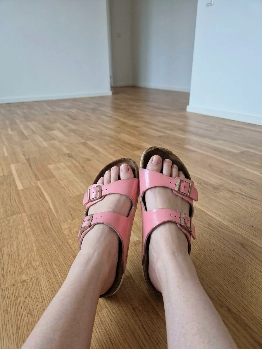 Birkenstock pink deck shoes with two adjustable straps and metal buckles, heavily worn.