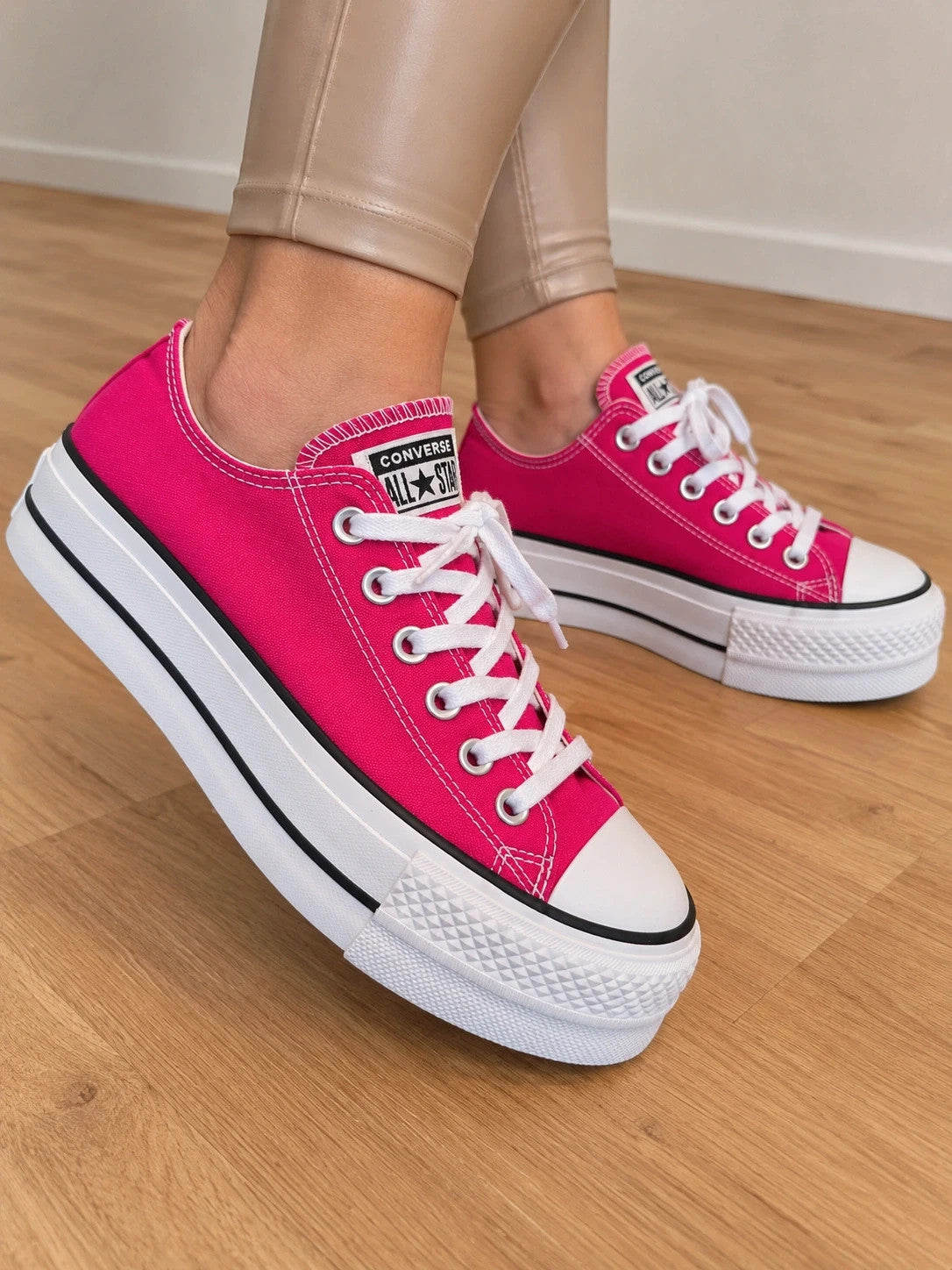 Converse pink Chuck Taylor All Star Lift Platform sneakers with white sole and logo.