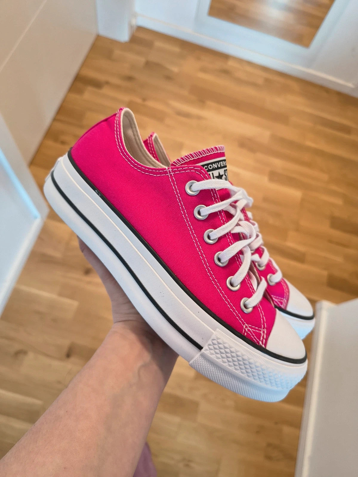 Converse pink Chuck Taylor All Star Lift Platform sneakers with white sole and logo.