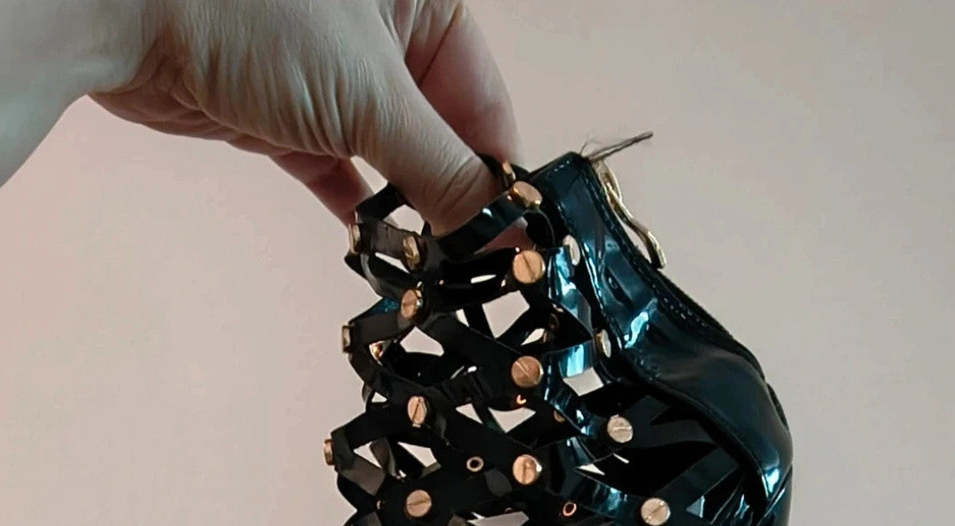 REI black high-heel sandals in patent finish with gold studs and open toe design.