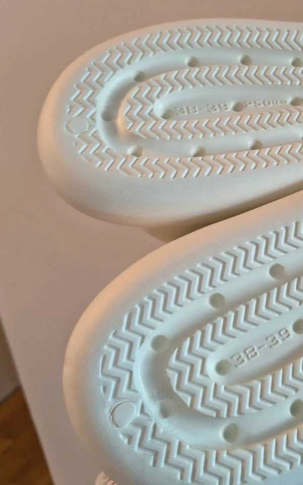 Hasen-Optik cream slides synthetic material with textured design and logo detail.