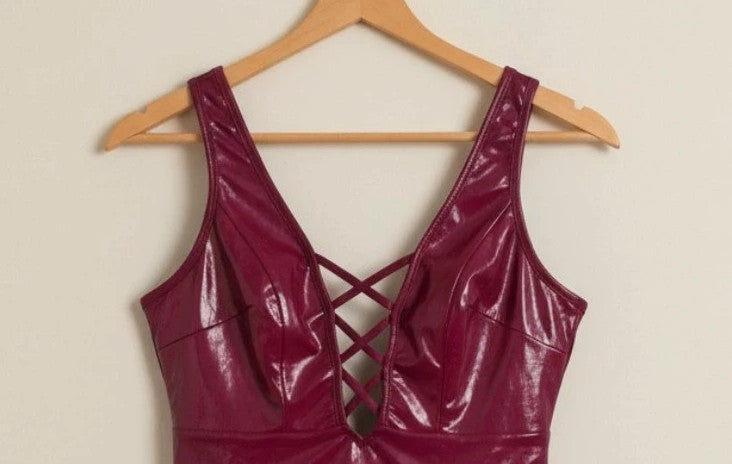 Bordeaux burgundy bandage dress with lace-up detail and glossy vinyl appearance.