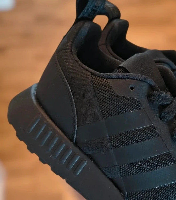 Adidas black trainers with synthetic and textile material, classic design, original box included.
