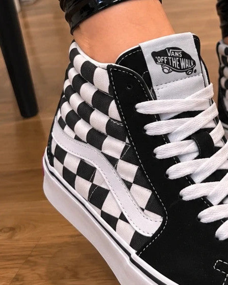 VANS black and white checkerboard high-top trainers with classic side stripe and leather material.