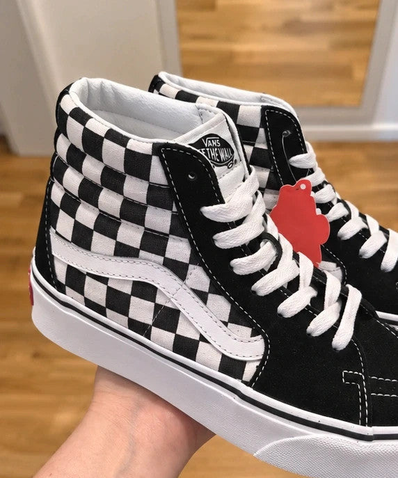 VANS black and white checkerboard high-top trainers with classic side stripe and leather material.