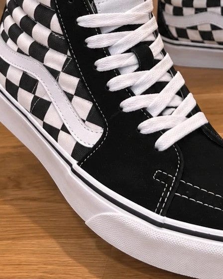 VANS black and white checkerboard high-top trainers with classic side stripe and leather material.