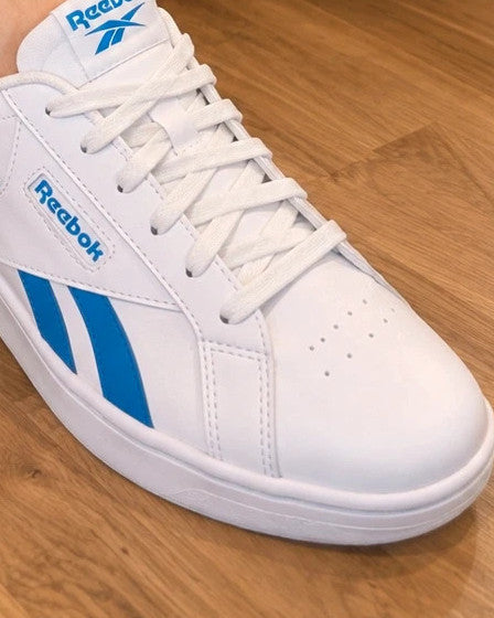 Reebok kids trainers white with blue details, classic lace-up design, synthetic material.