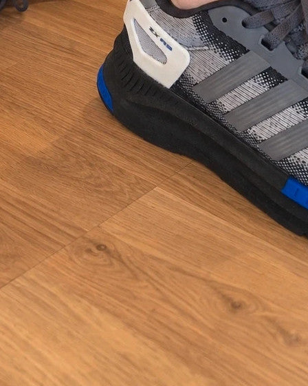 Adidas trainers grey black with blue accents, sporty design and distinctive sole.