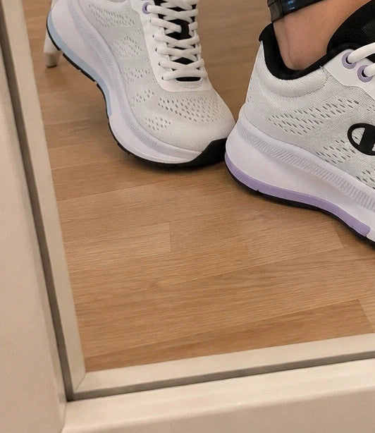 Champion white trainers with black and subtle lilac details, lightweight textile material.