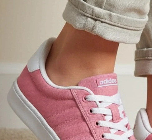 Adidas pink and white trainers with synthetic and textile materials, classic design.