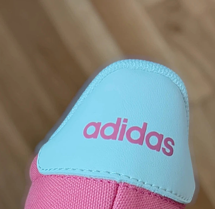 Adidas pink and white trainers with synthetic and textile materials, classic design.