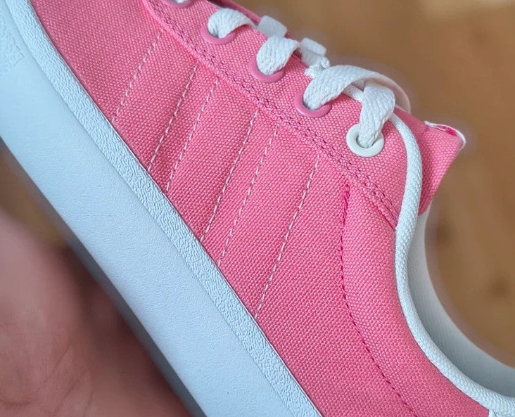 Adidas pink and white trainers with synthetic and textile materials, classic design.