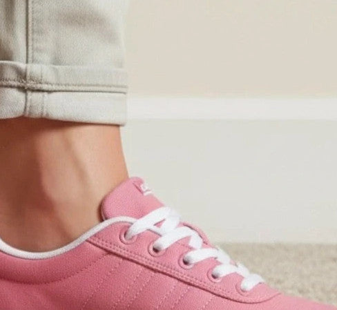 Adidas pink and white trainers with synthetic and textile materials, classic design.