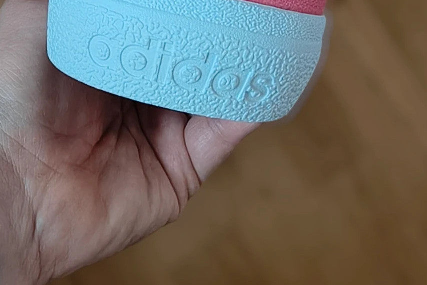 Adidas pink and white trainers with synthetic and textile materials, classic design.
