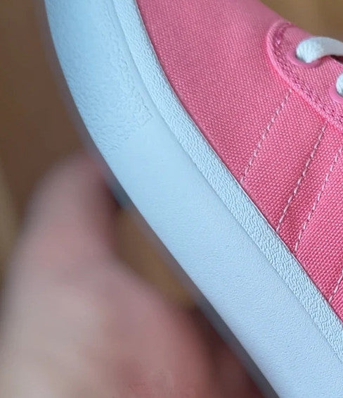 Adidas pink and white trainers with synthetic and textile materials, classic design.