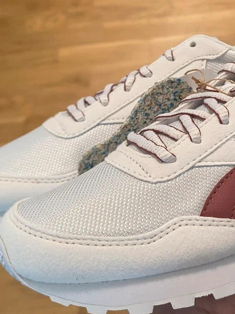 Reebok white trainers with synthetic and textile materials, featuring classic design elements.