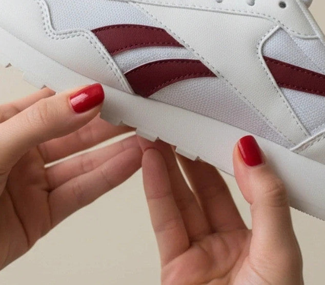 Reebok white trainers with synthetic and textile materials, featuring classic design elements.