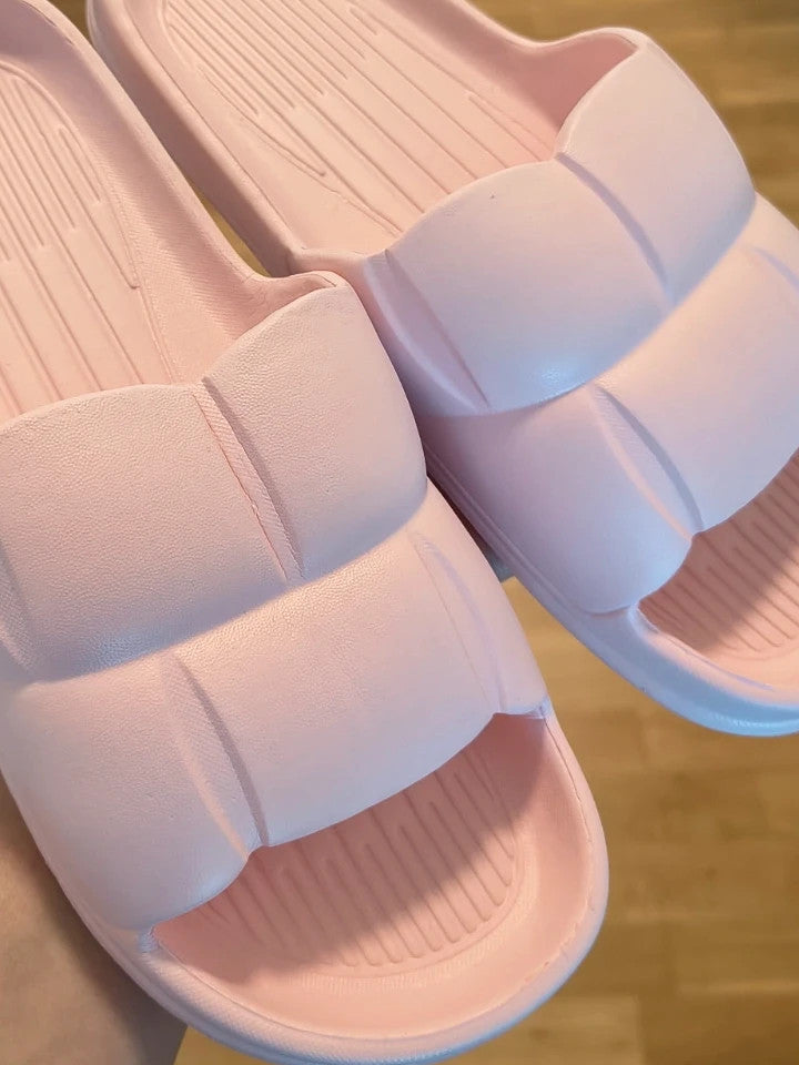 Slipper pink slides lightweight synthetic foam material with casual design.