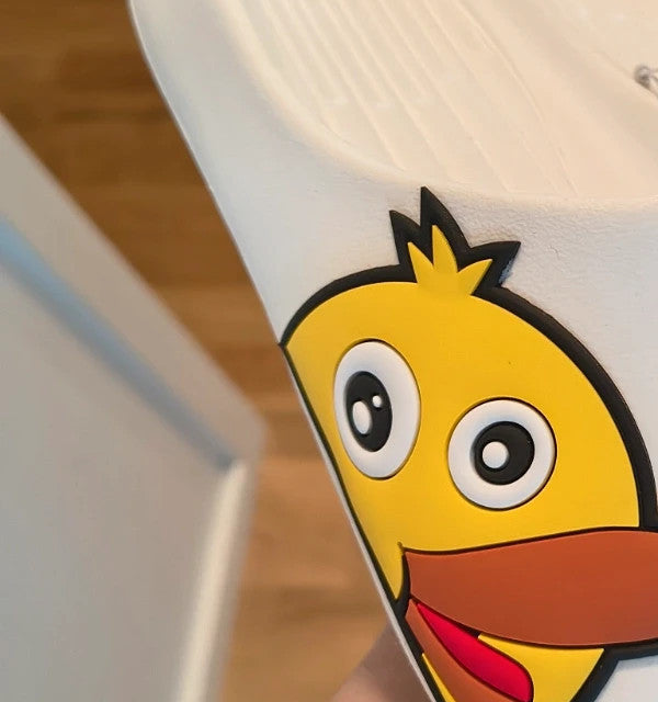 Slipper white and yellow slides with cartoon print and synthetic material.