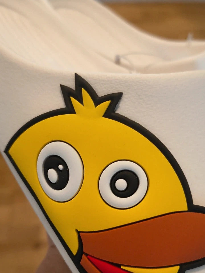 Slipper white and yellow slides with cartoon print and synthetic material.
