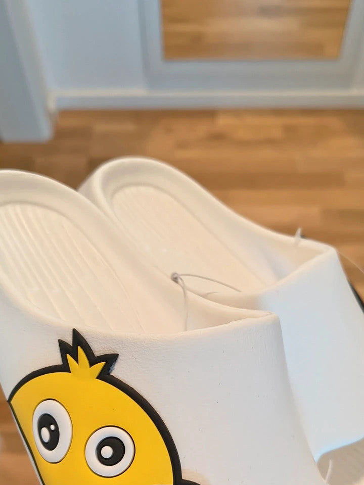 Slipper white and yellow slides with cartoon print and synthetic material.