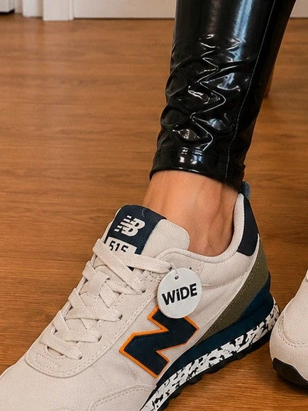 New Balance beige trainers with dark accents, textile and synthetic materials.