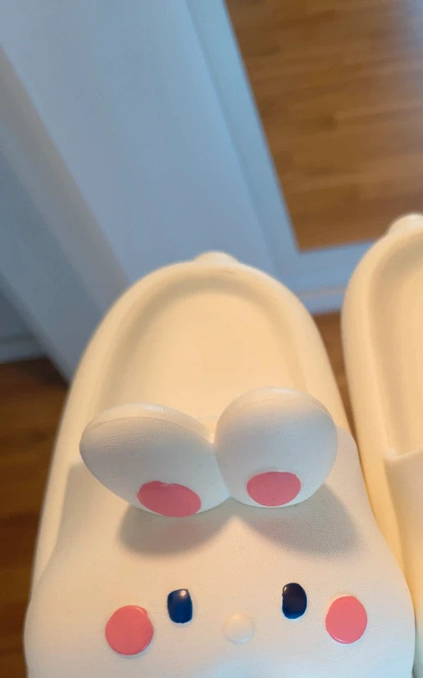 Slipper cream slides synthetic material with cartoon comic design and lightweight construction.