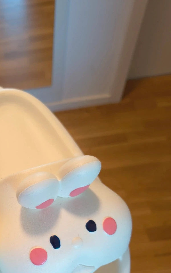 Slipper cream slides synthetic material with cartoon comic design and lightweight construction.