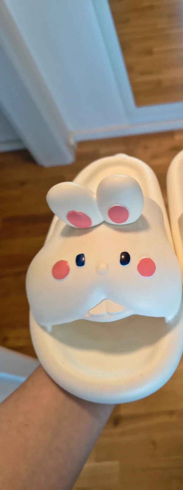 Slipper cream slides synthetic material with cartoon comic design and lightweight construction.