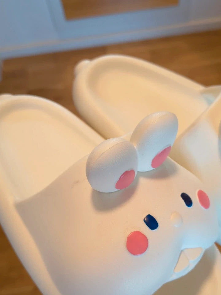 Slipper cream slides synthetic material with cartoon comic design and lightweight construction.