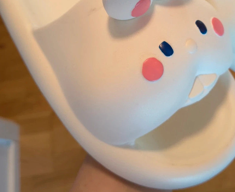 Slipper cream slides synthetic material with cartoon comic design and lightweight construction.