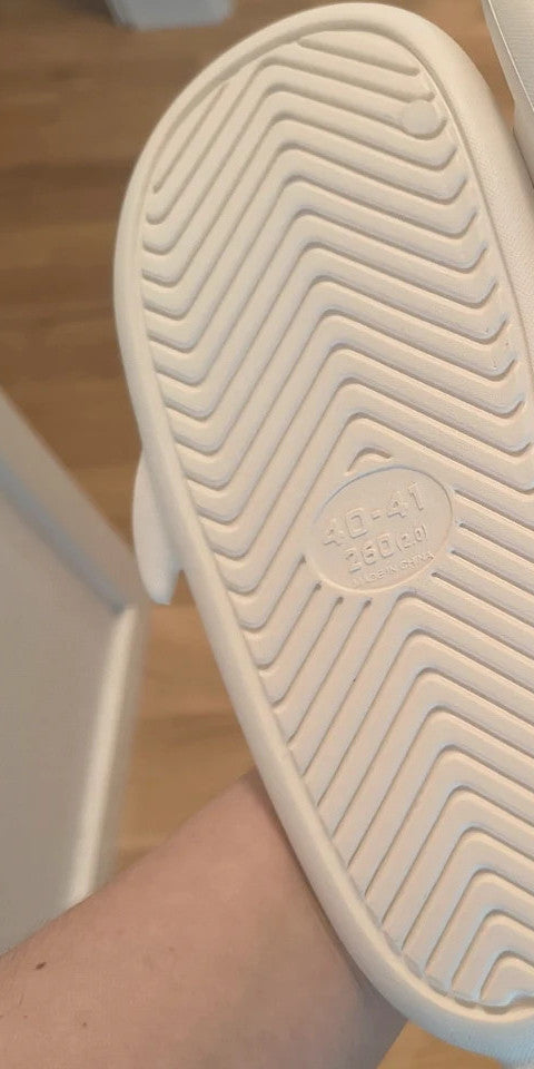 Perfekt cream slippers with monster design, featuring playful face and lightweight material.