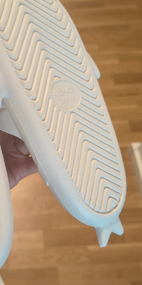 Perfekt cream slippers with monster design, featuring playful face and lightweight material.