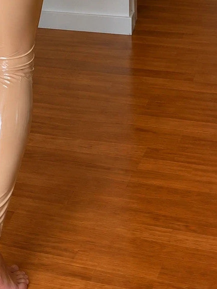 REI beige jumpsuit with glossy wetlook finish and front zipper detail.