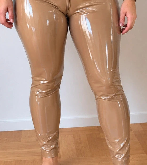 REI beige wetlook jumpsuit with front zipper and high collar, figure-hugging fit.
