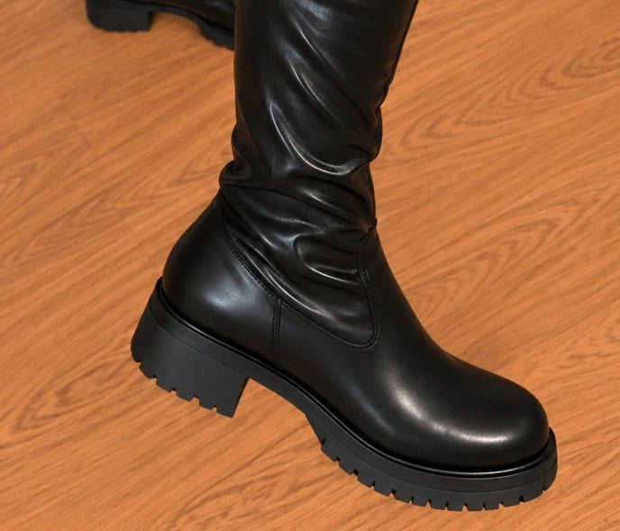REI black overknee boots with shiny finish, side zipper, and block heel.