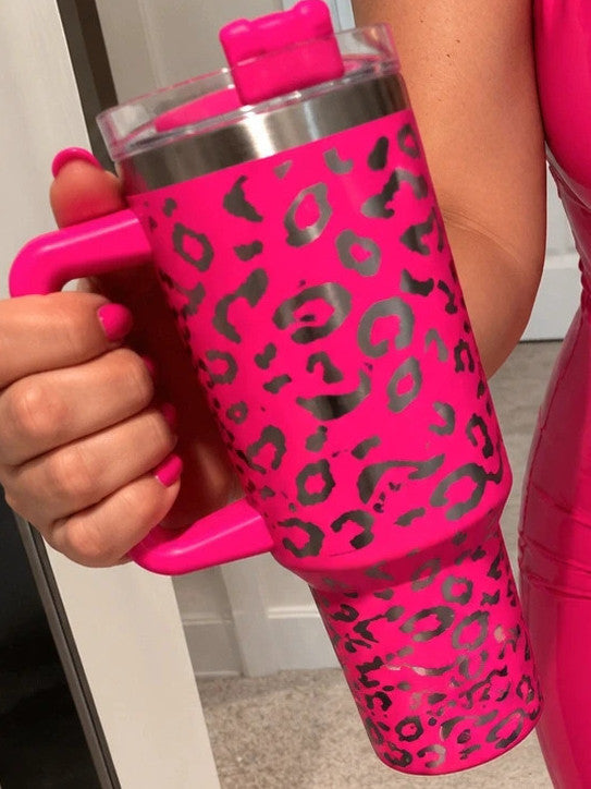 Pink tumbler with leopard print design, insulated, featuring handle and matching lid.