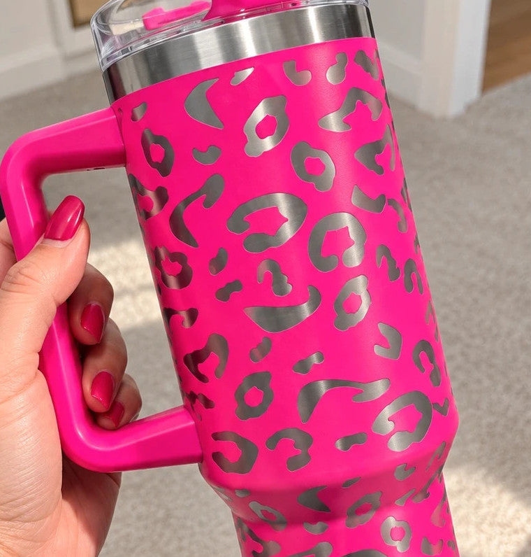 Pink tumbler with leopard print design, insulated, featuring handle and matching lid.