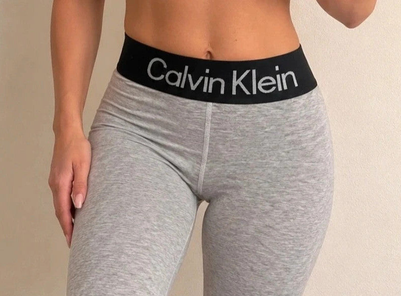 Calvin Klein grey bicycle tights with wide black logo waistband, fitted design.