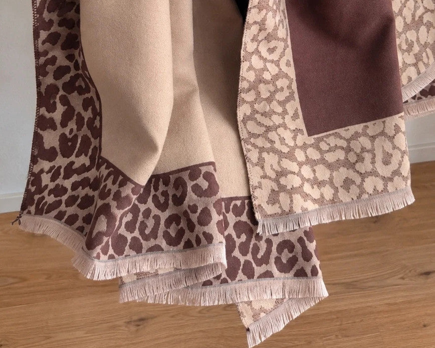 Beige scarf with brown leopard print edges and decorative fringes, reversible design.