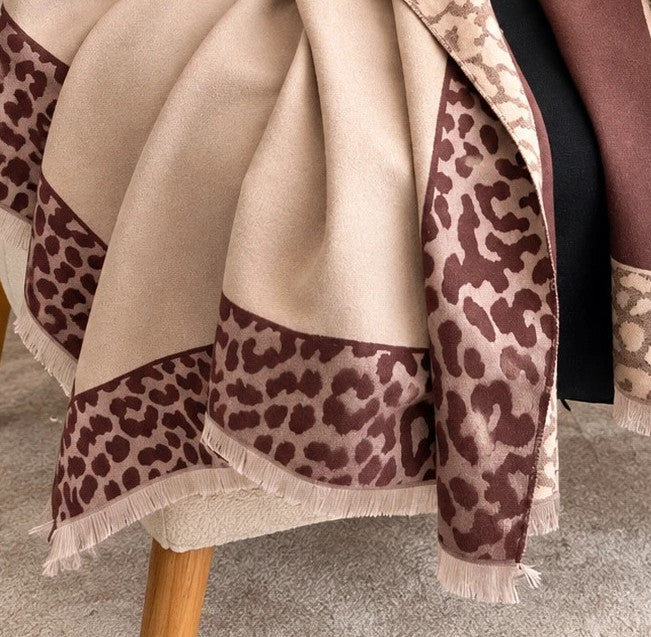 Beige scarf with brown leopard print edges and decorative fringes, reversible design.