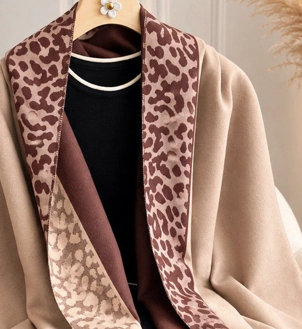 Beige scarf with brown leopard print edges and decorative fringes, reversible design.