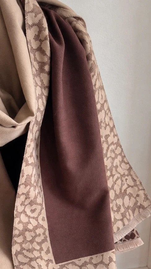 Beige scarf with brown leopard print edges and decorative fringes, reversible design.