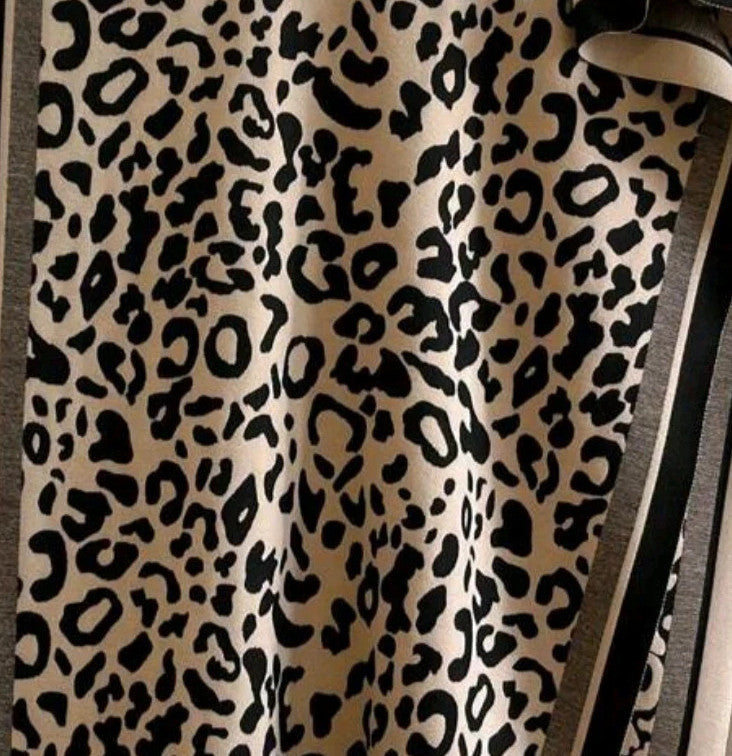 Beige scarf with black leopard print, fringed edges, reversible design, soft polyester material.