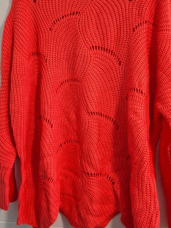 Pullover orange pink oversized sweater with decorative knit pattern and hole details.
