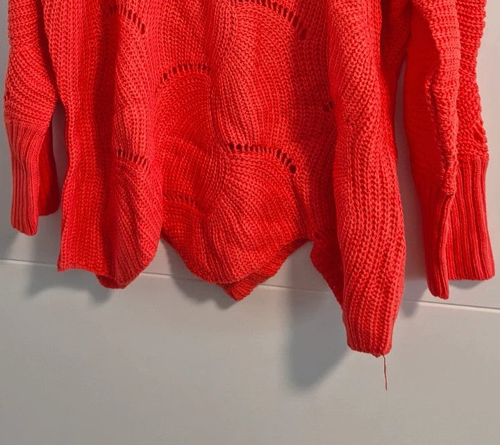 Pullover orange pink oversized sweater with decorative knit pattern and hole details.