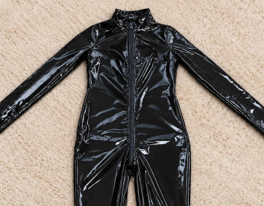 REI black jumpsuit with front zipper, fitted silhouette, and long sleeves.
